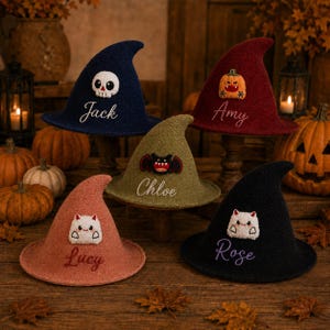May include: Five pointed witch hats in navy, burgundy, olive green, dusty rose, and black. Each hat features a unique embroidered character patch, including a skull, pumpkin, bat, and two ghosts, with personalized names embroidered below.