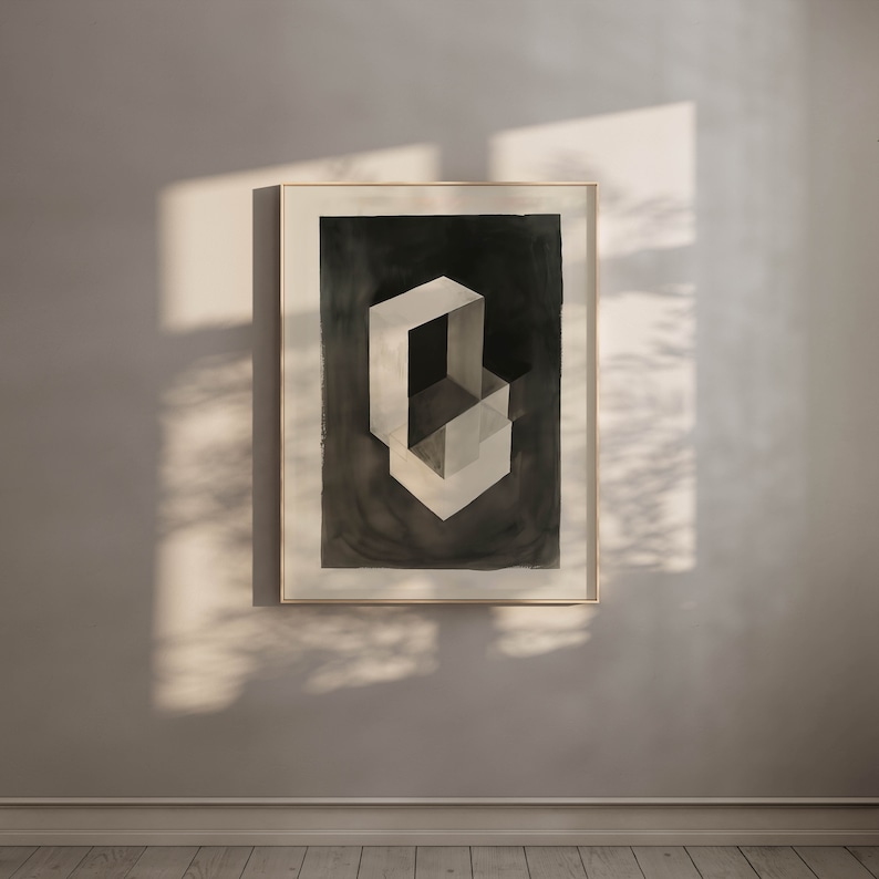 May include: A framed black and white abstract painting of a geometric shape. The shape is made up of overlapping squares and rectangles, creating a sense of depth and dimension. The painting is set against a light gray background.