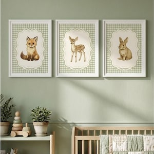 Könnte beinhalten: Drei gerahmte Kunstdrucke mit Waldtieren. Die Drucke zeigen einen Fuchs, ein Reh und ein Kaninchen, jeweils vor einem cremefarbenen Hintergrund mit dekorativem Rand und grünem Vichymuster. Die Rahmen sind weiß.