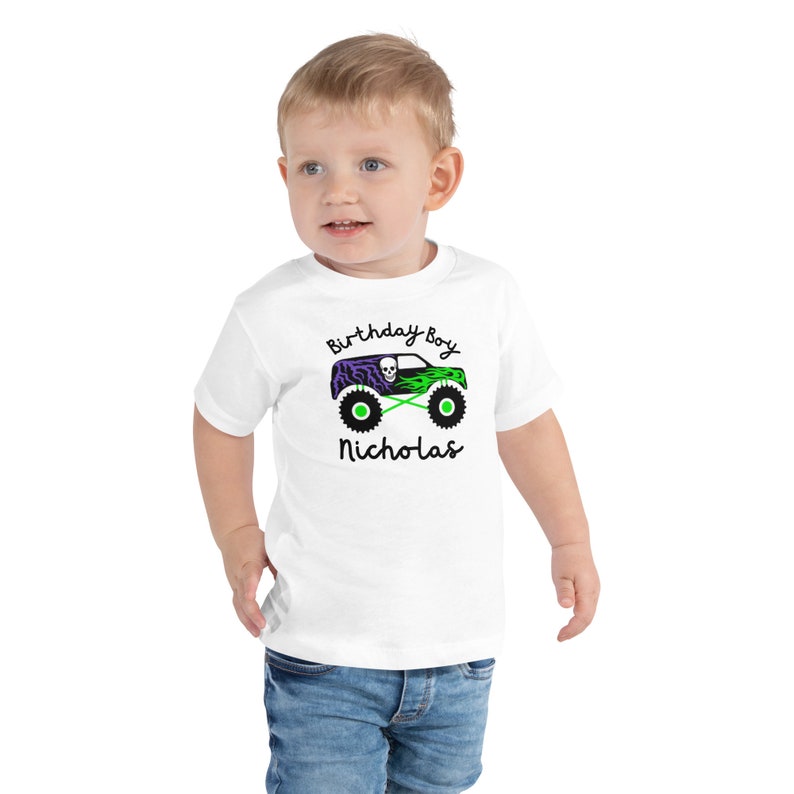 May include: White toddler t-shirt with a green monster truck graphic and the text "Birthday Boy Nicholas".