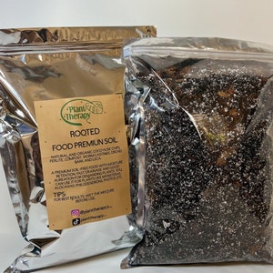 May include: Two silver bags of Rooted Food Premium Soil. The bag on the left has a brown label with the text "Plant Therapy Rooted Food Premium Soil" and a list of ingredients. The bag on the right is clear and shows the soil inside.