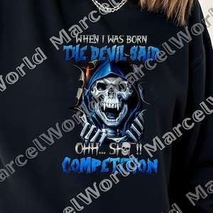 May include: Black sweatshirt featuring a graphic of a skull wearing a blue hood, with the text "WHEN I WAS BORN THE DEVIL SAID OHH...SH*T...COMPETITION" in blue and white. The design is centered on the front of the sweatshirt.