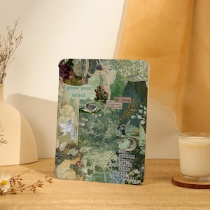 Könnte beinhalten: Ein grüner und weißer Notizbuchumschlag im Collage-Stil mit dem Text "grow your mind." und "She dreams more often than she sleeps." Der Umschlag zeigt außerdem eine Fee, Blumen und andere naturinspirierte Bilder.
