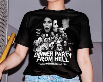 May include: Black t-shirt with a graphic print of a group of women with a skull in the center. The text "Dinner Party From Hell" is printed below the graphic. The text "The Real Nightmare of Beverly Hills" is printed below the title.