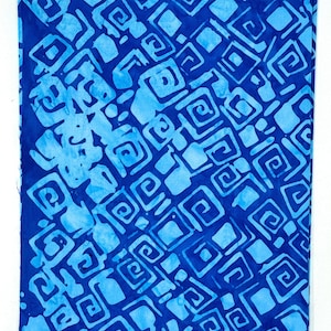 Könnte beinhalten: Blauer und hellblauer Batikstoff mit einem geometrischen Muster aus Quadraten und Wirbeln. Der Stoff trägt den Aufdruck "Batik-123".