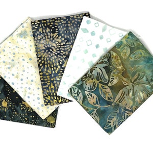 Könnte beinhalten: Sechs Stoffquadrate mit verschiedenen Mustern und Farben. Die Stoffe zeigen Designs wie goldene Sternausbrüche, blaue und goldene Punkte sowie grüne und blaue Blätter. Die Quadrate sind fächerförmig vor weißem Hintergrund angeordnet.