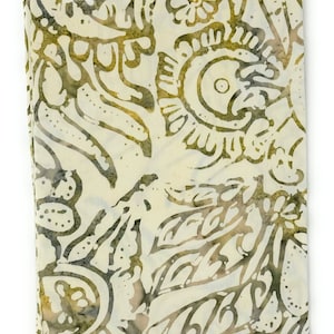 Könnte beinhalten: Ein beigefarbener Stoff mit einem braunen Batik-Muster aus Blättern, Blumen und Kreisen. Der Stoff hat ein Etikett mit der Aufschrift "Batik-102".