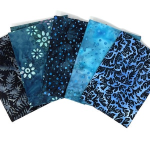 Könnte beinhalten: Ein Set aus sechs Stoffquadraten in verschiedenen Blautönen mit unterschiedlichen Mustern, darunter Blumen, Punkte und Paisley.