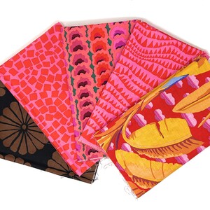 Peut inclure: Cinq échantillons de tissu avec différents motifs. Les échantillons sont roses, rouges, oranges et bruns avec des motifs géométriques et floraux.