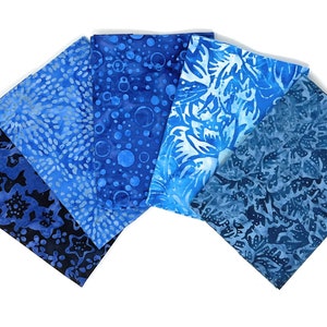 Könnte beinhalten: Ein Set aus sechs blauen Batik-Stoffquadraten mit verschiedenen Mustern. Die Stoffe zeigen eine Vielzahl von Blautönen und weißen Akzenten.