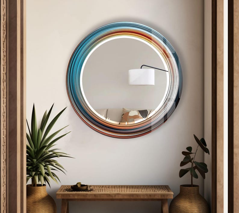 a round mirror hanging on a wall above a table