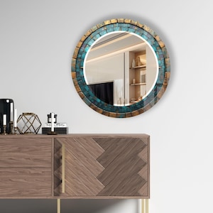 a round mirror on a wall above a dresser