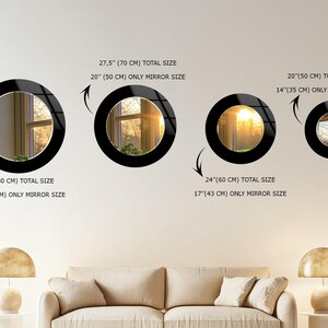 a living room with a white couch and three mirrors on the wall