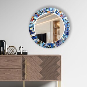 a mirror that is on the wall above a dresser