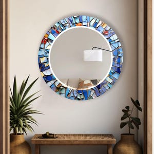 a round mirror mounted on a wall above a table