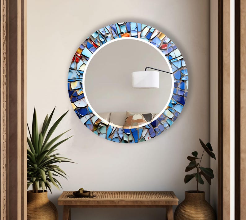 a round mirror mounted on a wall above a table