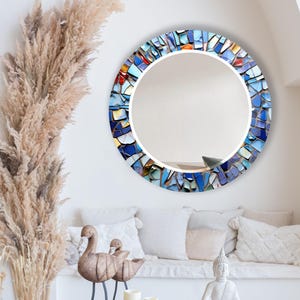 a living room filled with furniture and a round mirror