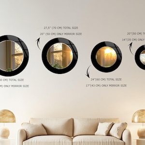 a living room with a white couch and three mirrors on the wall