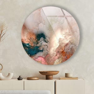 Könnte beinhalten: Ein rundes Wandkunstwerk mit abstraktem Design. Das Kunstwerk zeigt eine Mischung aus Farben, darunter Türkis, Pfirsich, Rosa und Weiß, wodurch ein wolkenartiger Effekt entsteht. Das Stück ist an einer neutralfarbenen Wand befestigt und verleiht eine moderne Note.