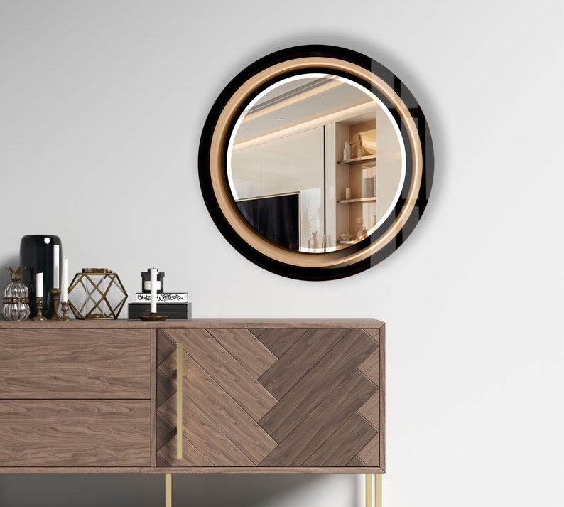 a round mirror on a wall above a dresser