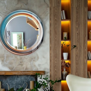 a living room with a fireplace and a round mirror