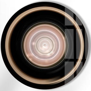 Può includere: Un decoro da parete rotondo, nero e dorato con cerchi concentrici e un centro bianco. L'anello esterno è dorato e gli anelli interni sono neri.