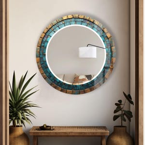 a round mirror on a wall above a table