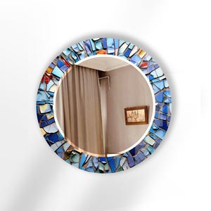 a round mirror with a blue and red mosaic design