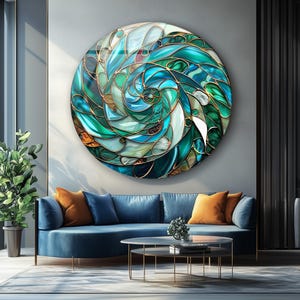 Può includere: Un'opera d'arte murale rotonda con un design a vetrata. L'opera presenta un motivo a spirale di tonalità verde acqua, turchese e verde, accentuato da linee color oro. L'opera è montata su una parete sopra un divano blu, con un diametro di circa 100 cm.