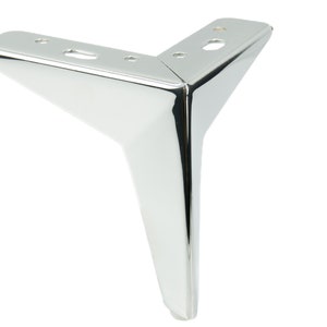 Può includere: Un piedino per mobili in metallo cromato con base triangolare e punta appuntita.