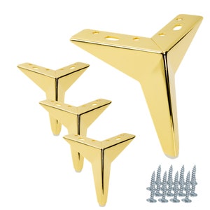 May include: Set of four gold metal furniture legs with a triangular shape. Each leg has four holes for mounting and comes with screws.