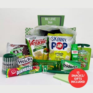 May include: A gift box containing 13 snacks and items including a bag of SkinnyPop popcorn, Garden Veggie Straws, a Lenny & Larry's cookie, a Nature Valley bar, a GoGo squeeZ pouch, Welch's fruit snacks, an Airheads candy bar, Trident gum, and socks.