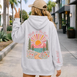 Youth Camp Faith Hoodie Christian Sweatshirt Teen Girl Bible Verse Scripture Design Walk In His Light Theme Inspirational Clothing Gift Teenage Daughter Spiritual Wear Mountain Lake Scene Floral Details Soft Comfortable Cotton Poly Blend