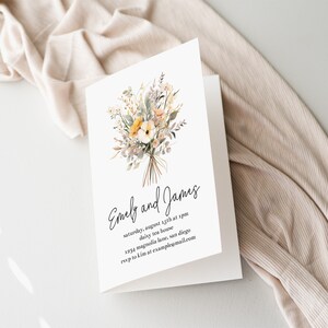 Puede incluir: Una tarjeta blanca con una ilustraci&oacute;n floral y el texto "Emely and James" seguido de los detalles de una recepci&oacute;n de boda: "s&aacute;bado 13 de agosto a las 5 pm, daisy tea house, 1294 magnolia lane, san diego, esvp a kim en example@mail.com".