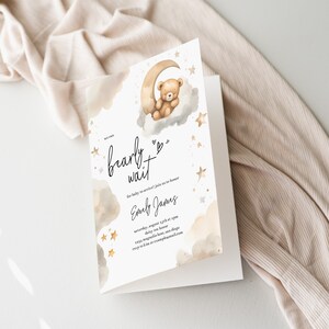 Op de afbeelding: Een babyborrel uitnodiging met een aquarel illustratie van een teddybeer die slaapt op een halve maan. De uitnodiging luidt "bearly wait" en bevat de tekst "Onze baby is onderweg! Doe mee om Emily James te eren Zaterdag 12 augustus om 14:00 uur. 123 Magnolia Lane, San Diego RSVP naar: emilyjames@email.com"
