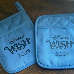 May include: Two blue quilted oven mitts with the text "Disney Wish 2024" in black.
