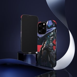 May include: Two phone cases, one black and one with a graphic of a hooded figure in a blue and red colour scheme. The hooded figure is holding a weapon and has a red and blue colour scheme.