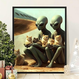 May include: A framed art print featuring two green-skinned aliens holding several fluffy orange and gray cats. The aliens are seated, with a spaceship in the background. The artwork has a whimsical and surreal theme.