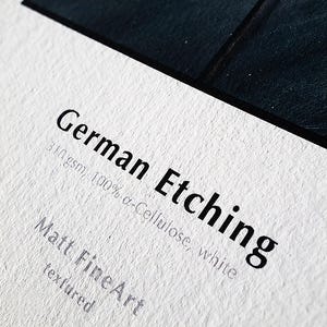The image is a close-up of a white surface with text and a black border.