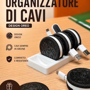Peut inclure: Organisateur de câbles en forme de biscuit Oreo. Le design noir et blanc comprend une base blanche avec trois fentes pour maintenir les câbles. Le texte "ORGANIZZATORE DI CAVI" est en haut de l'image.
