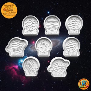 May include: A collection of white plastic cookie cutters depicting the planets: Mercury, Jupiter, Mars, Saturn, Earth, Neptune, Venus, and Uranus. Each cutter is labelled with the planet's name. The background shows a starry galaxy.