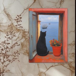 Op de afbeelding: Een zwarte kat zit in een raam en kijkt uit op een zeezicht. Het raam is geschilderd in een rode lijst met een blauwe deur. Een plant in een pot met rode bloemen staat op de vensterbank. De tekst "craftyharmonies.etsy.com" staat onderaan de afbeelding.