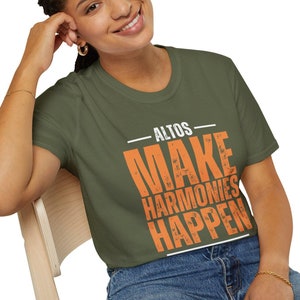 May include: A woman wearing a green t-shirt with the text "ALTOS MAKE HARMONIES HAPPEN" in orange. The shirt has a distressed look.