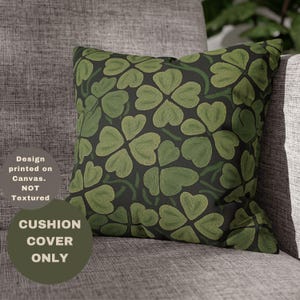Peut inclure: Une housse de coussin verte et noire avec un motif de trèfles à quatre feuilles. Le texte "CUSHION COVER ONLY" est imprimé dans le coin inférieur gauche de l'image.