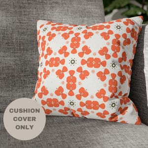 May include: Orange and white floral patterned cushion cover. The cover is made of a soft, comfortable fabric and features a repeating pattern of orange flowers on a white background.