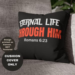 Puede incluir: Funda de cojín negra con texto blanco que dice "Eternal Life Through Him" y la referencia bíblica "Romanos 6:23" en texto rojo.