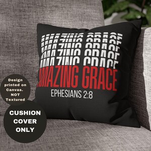 Op de afbeelding: Zwarte kussenhoes met witte tekst die meerdere keren "AMAZING GRACE" herhaalt. De tekst "EPHESIANS 2:8" is in wit onder de hoofdtekst gedrukt.