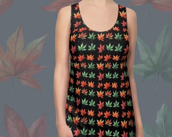 May include: Black racerback dress featuring a pattern of autumn leaves in red, orange, and green. The dress has a scoop neckline and a fitted shape. The text "RACERBACK DRESS" and "AUTUMN LEAVES 1" are visible.