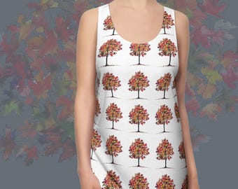 May include: White racerback dress featuring a repeating pattern of trees with red, orange, and yellow autumn leaves. The dress has a scoop neckline and is sleeveless. Text reads "RACERBACK DRESS" and "AUTUMN LEAVES 3".