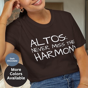 Pode incluir: T-shirt castanho escuro com o texto branco "ALTOS: NEVER MISS THE HARMONY". A camisa é de gola redonda. Texto adicional indica que mais cores estão disponíveis.